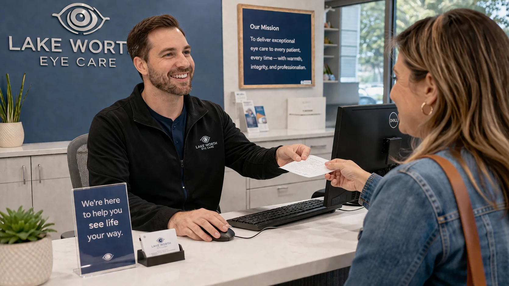 Friendly eye care staff member helping a patient at the front desk in a modern clinic